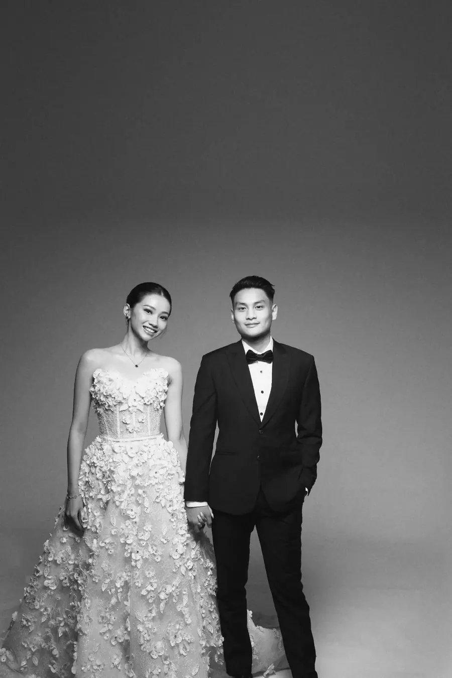 Matthew in a tuxedo and Karin in a floral gown, standing side by side